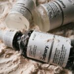 Skincare serum bottles on textured sandy surface — retinol week by week results timeline guide