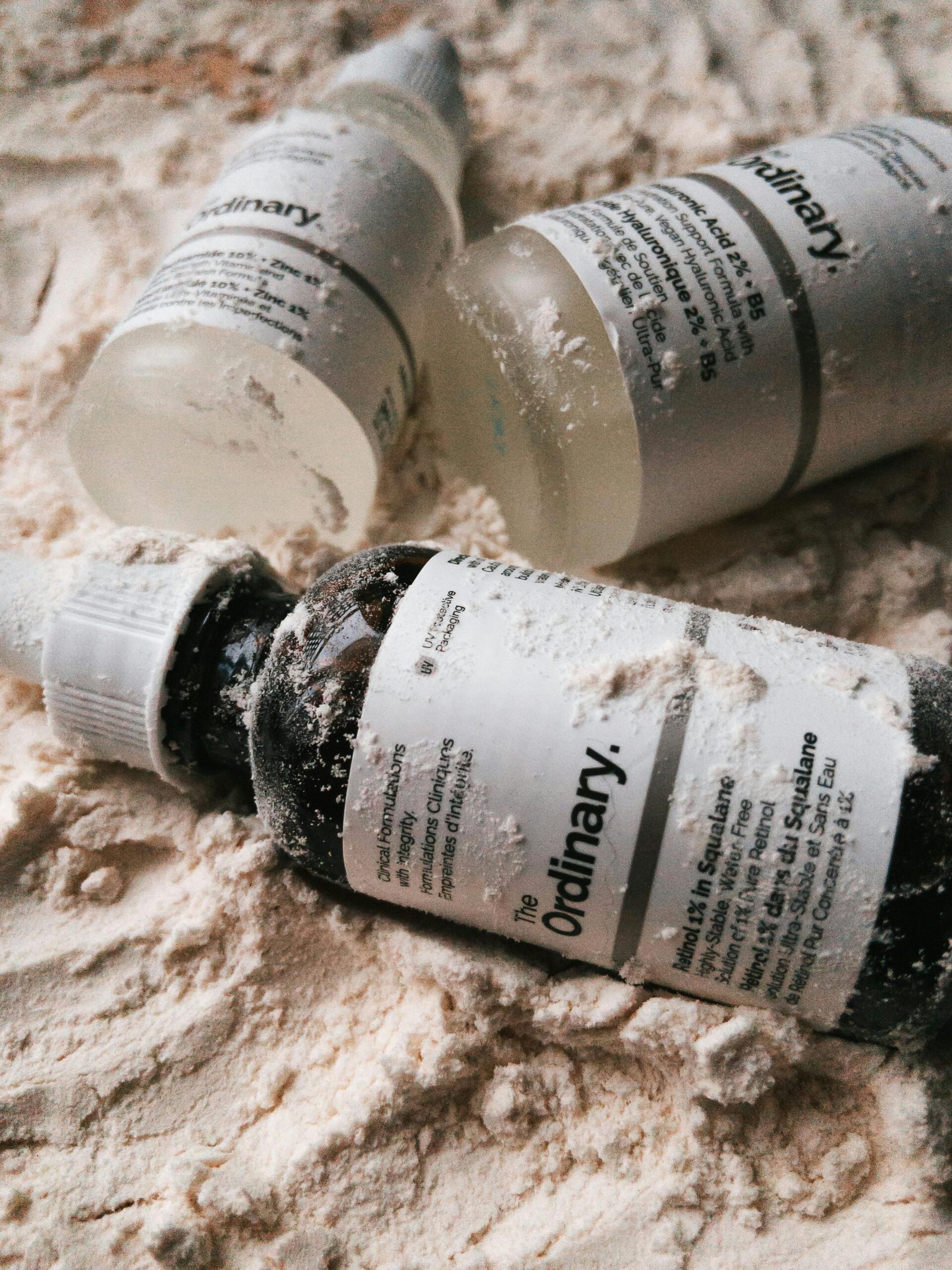 Skincare serum bottles on textured sandy surface — retinol week by week results timeline guide