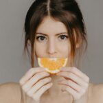 Woman applying vitamin C serum in the morning as part of her dark spot skincare routine in her 30s