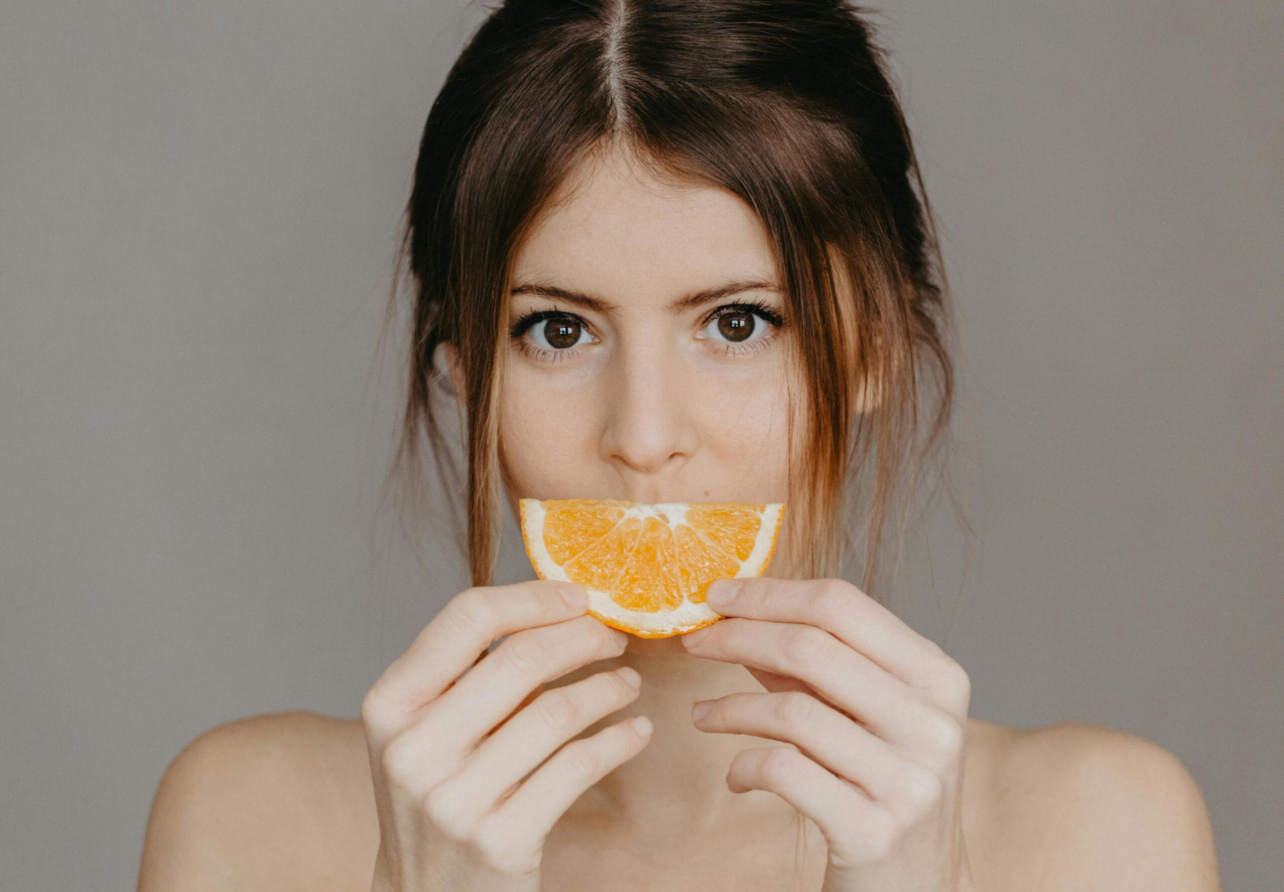 Woman applying vitamin C serum in the morning as part of her dark spot skincare routine in her 30s