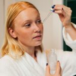 Woman applying hyaluronic acid serum with a dropper as part of her skincare routine — best hyaluronic acid serums for women in their 30s