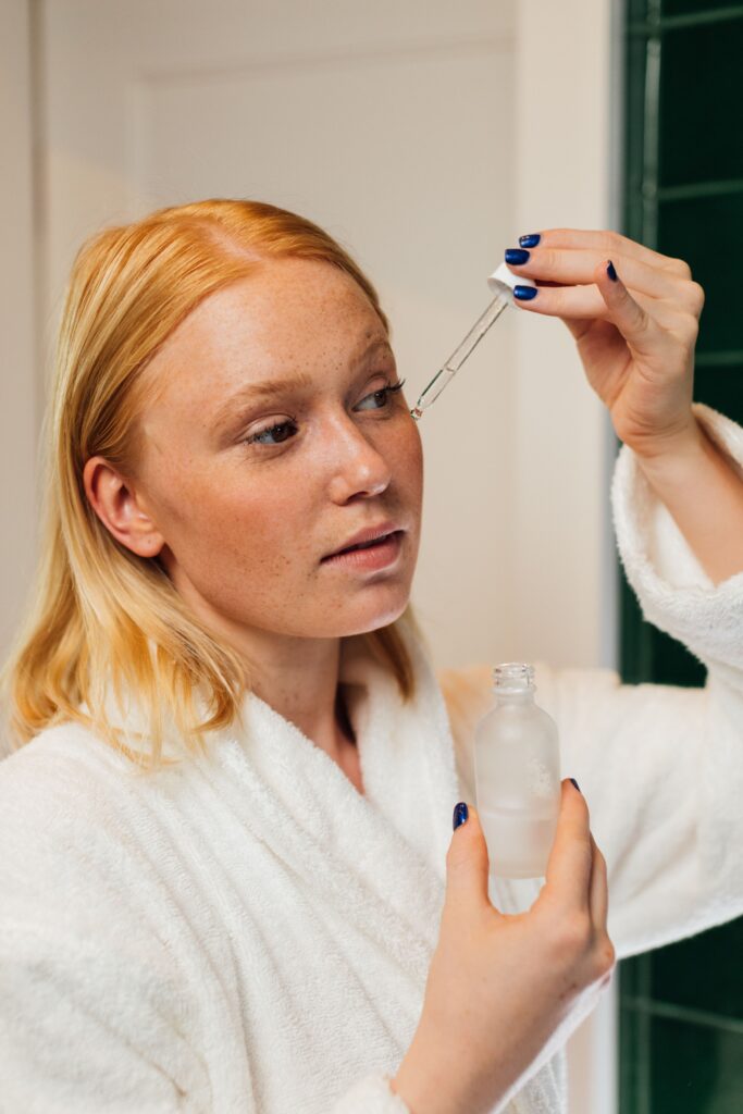 Woman applying hyaluronic acid serum with a dropper as part of her skincare routine — best hyaluronic acid serums for women in their 30s